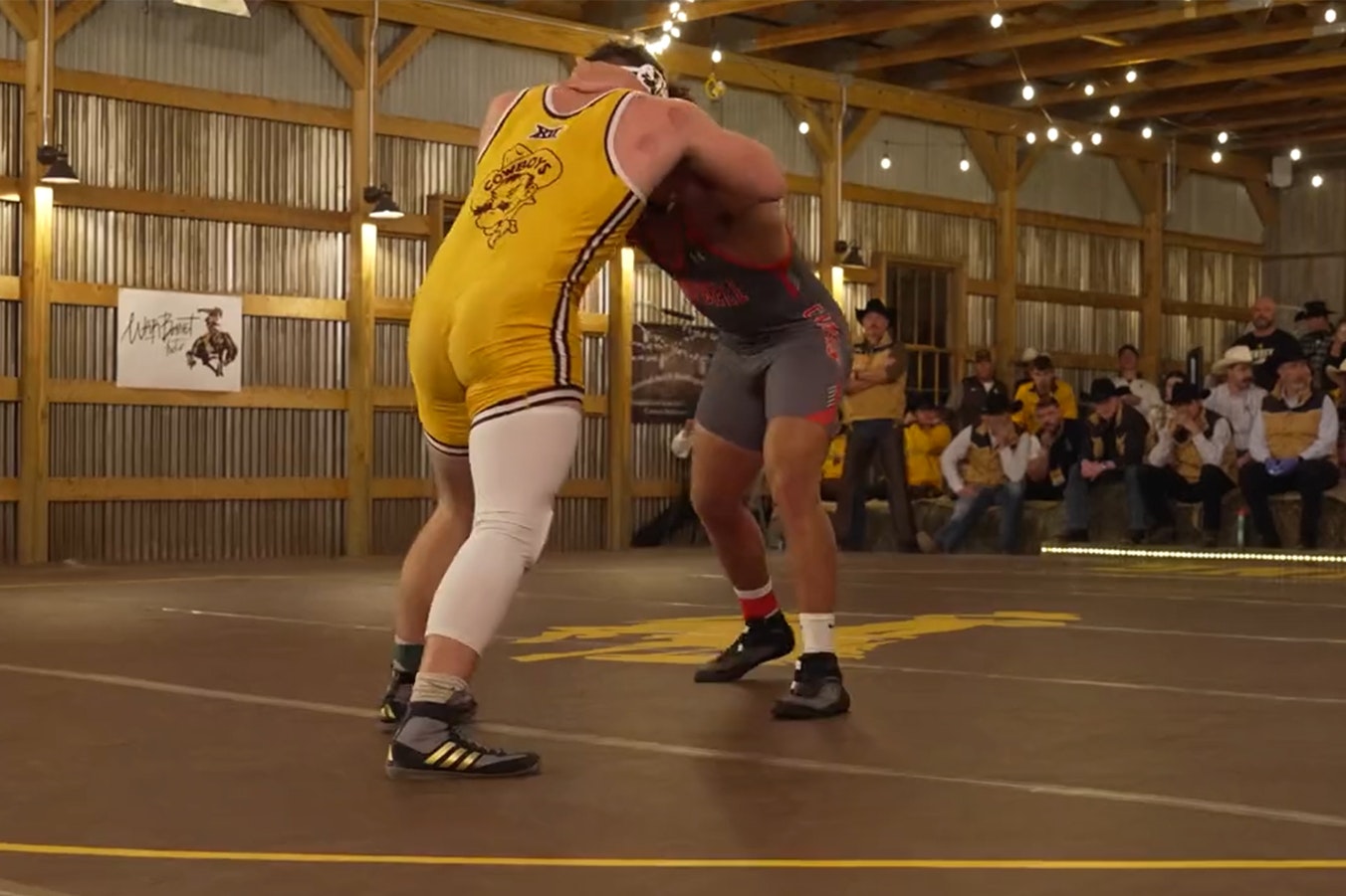 A University of Wyoming grappler ties up with an opponent from Campbell University in a barn on the Deerwood Ranch in Centennial, Wyoming, dubbed "The Battle in the Barn."