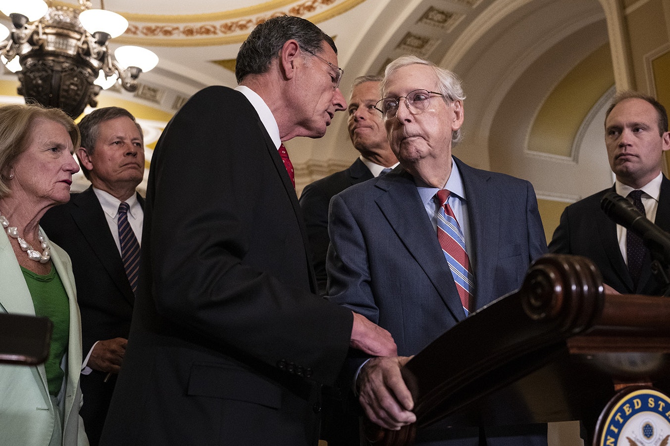 Sen. John Barrasso, R-Wyoming, reaches out to help Senate Minority Leader Mitch McConnell, R-Kentucky, after McConnell froze and stopped talking at the microphones during a news conference after a lunch meeting with Senate Republicans at the U.S. Capitol on Wednesday.