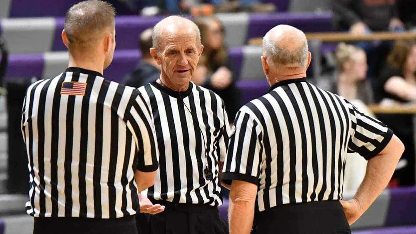 A team of referees meet before the beginning of a Wyoming high school basketball game.