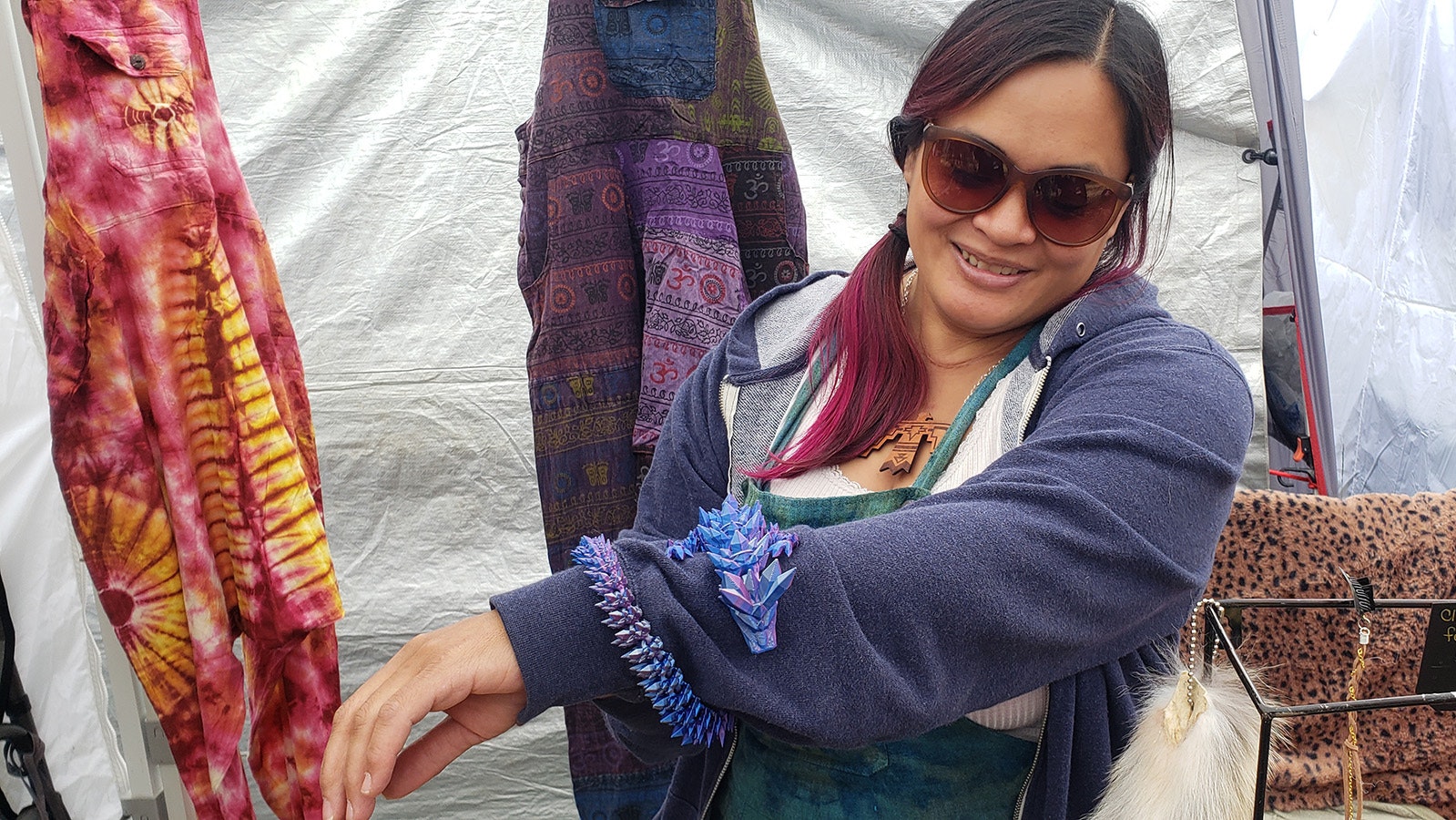 Thuvan Ahrens demonstrates how her posable 3D-printed dragons can wrap around an arm looking almost like a pet. She was part of an army of vendors with hand crafted wares for sale at the Beartrap Summer Festival.