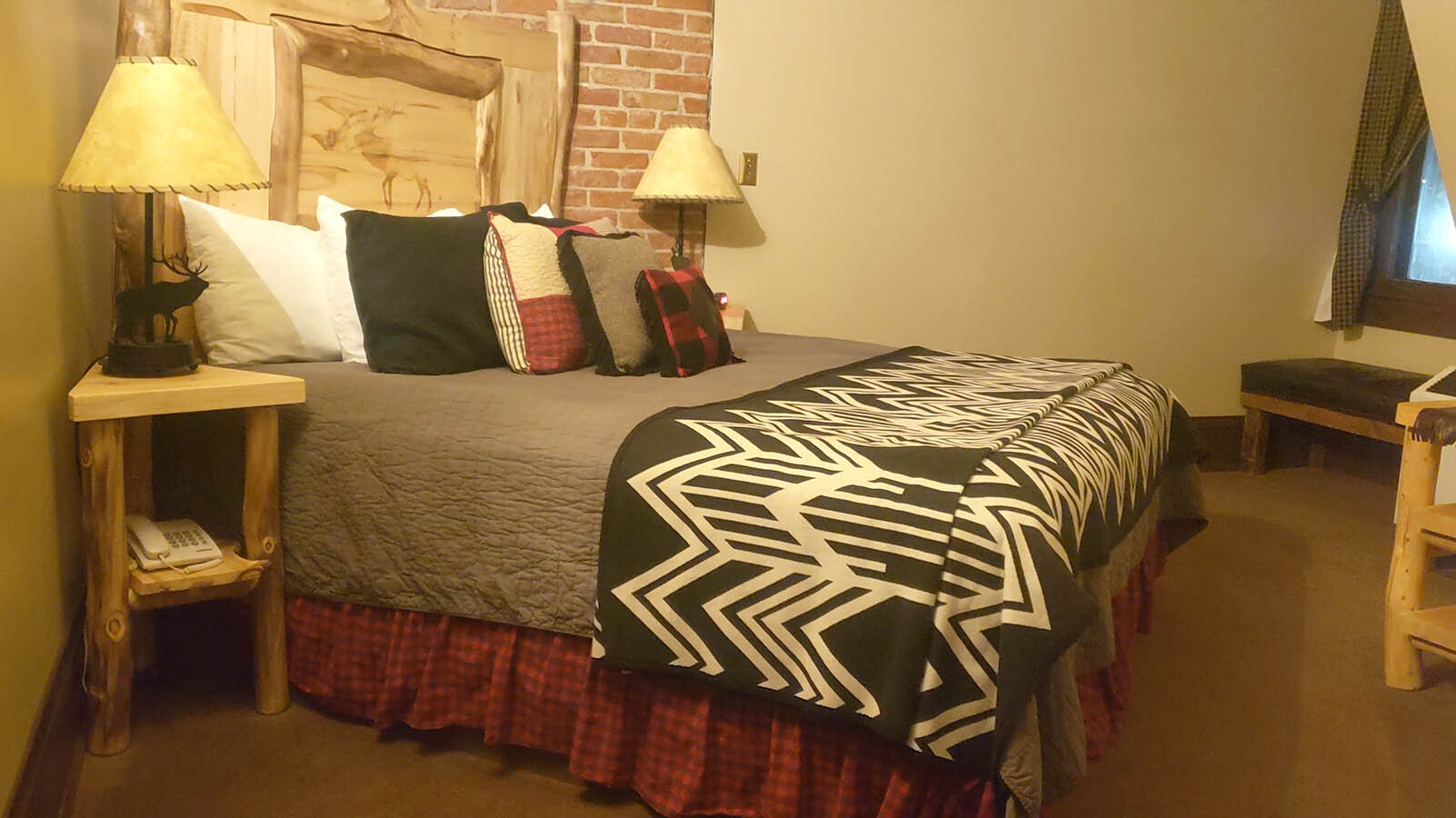 Bed in the Black Elk room shows patterns reminiscent of American Indian motifs and rustic furniture.