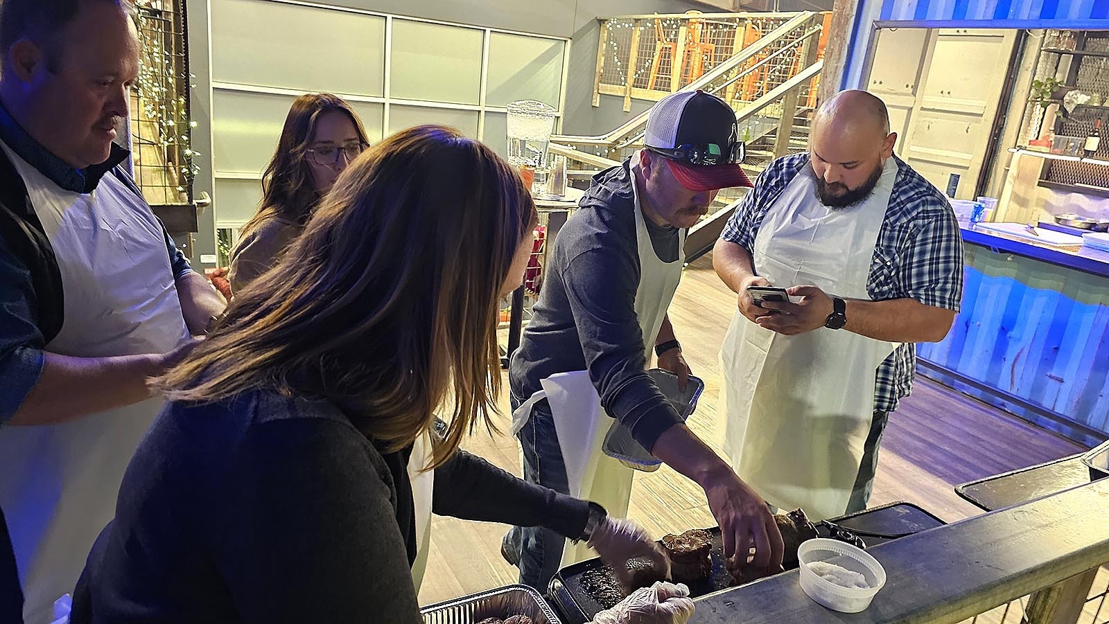 Members of a beef Wellington class at Railspur gather around to seer their beef tenderloins to give it a nice brown color.