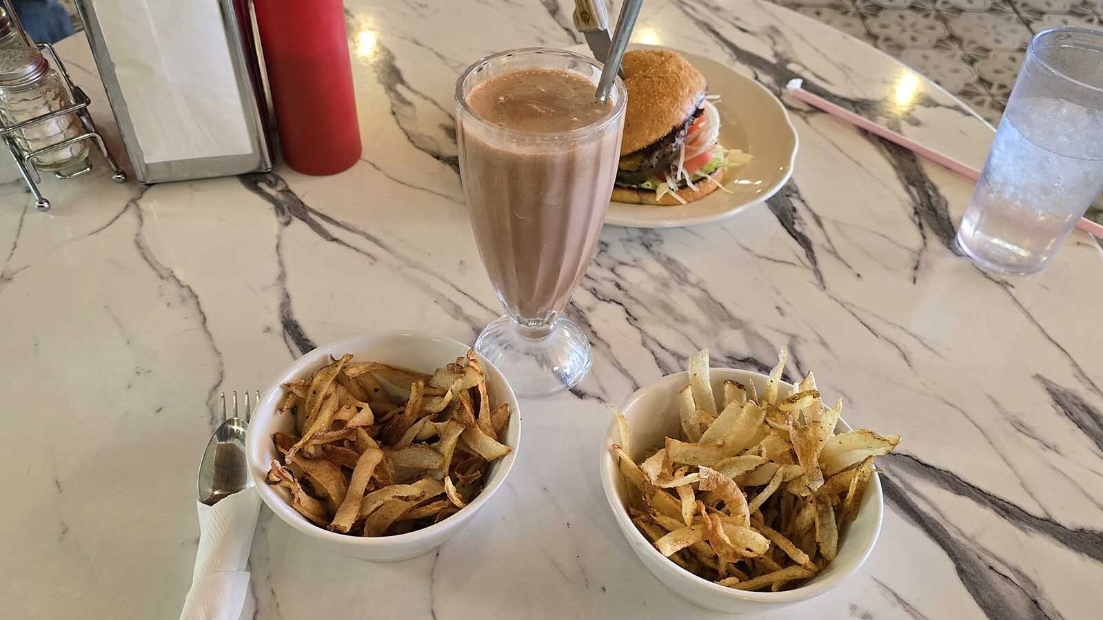The taste test arrives. One bowl are tallow fries, and one bow was fried in seed oils. A chocolate malt is on standby for the taste test, as well as a ranch-raised, grass-fed burger from the Chugwater Soda Fountain.