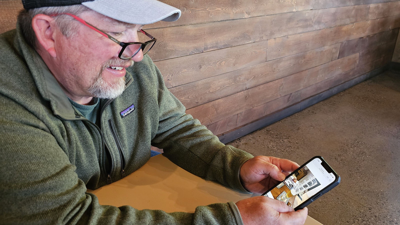 Beer Judge Paul Dey looks through photos on his phone of past beers he's consumed or judged.