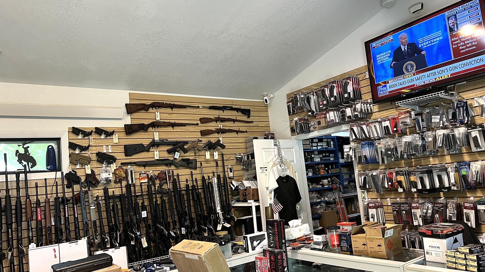 A television in the Dave’s Guns shop in Larmie broadcasts President Joe Biden speaking at a gun control rally on Tuesday, the same day his son, Hunter Biden, was convicted for gun-related felonies.