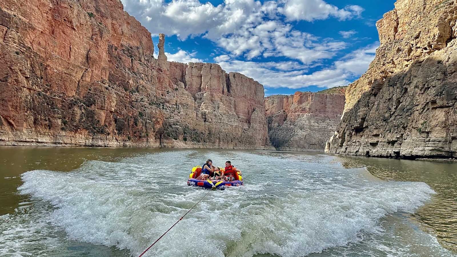 Three kids are having a thrill bouncing along the waves in the canyon on this day.
