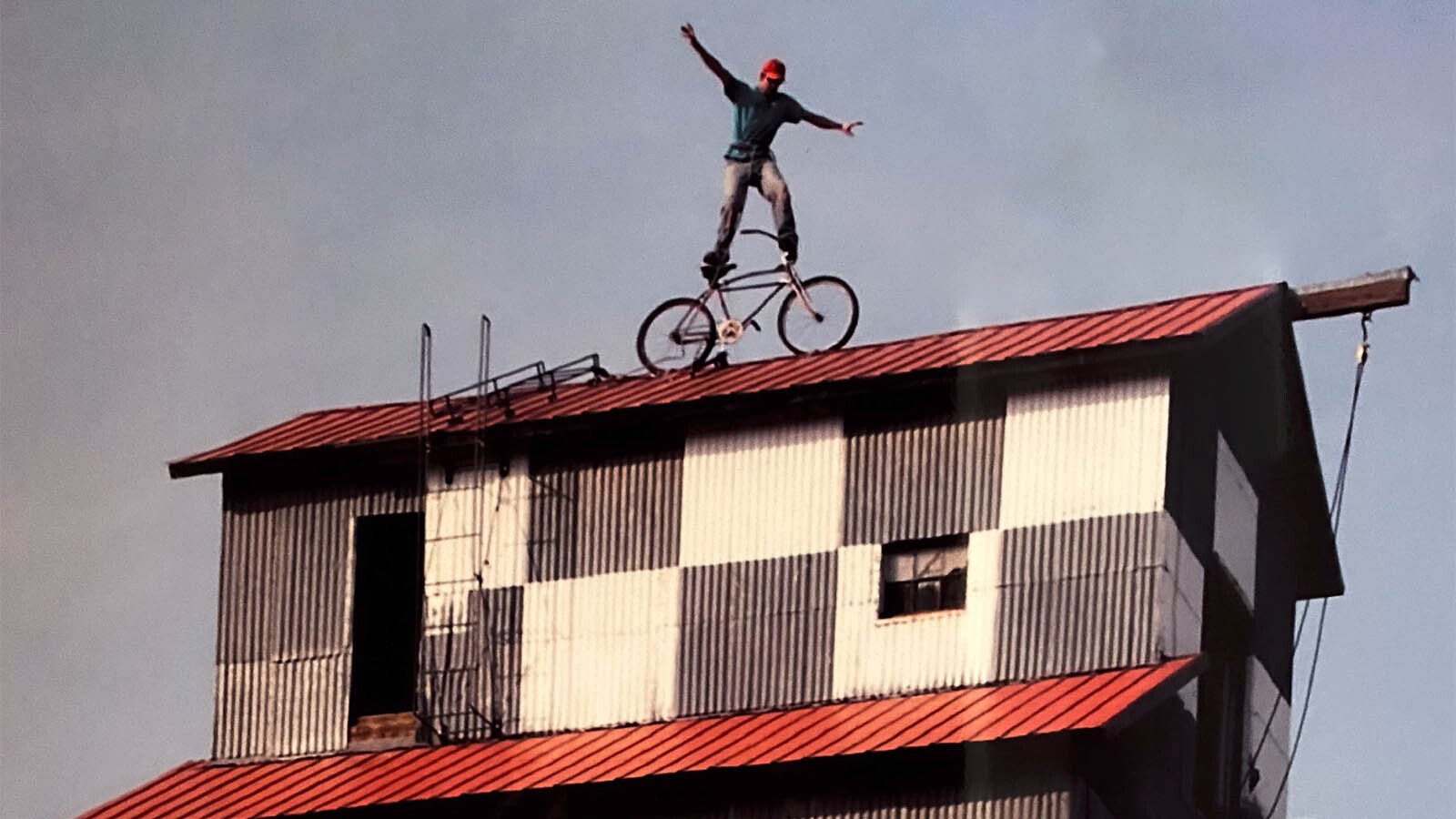 Trey Warren stands on top of a mountain bike he bolted to the roof of the 75-foot-tall Lander Elevator.