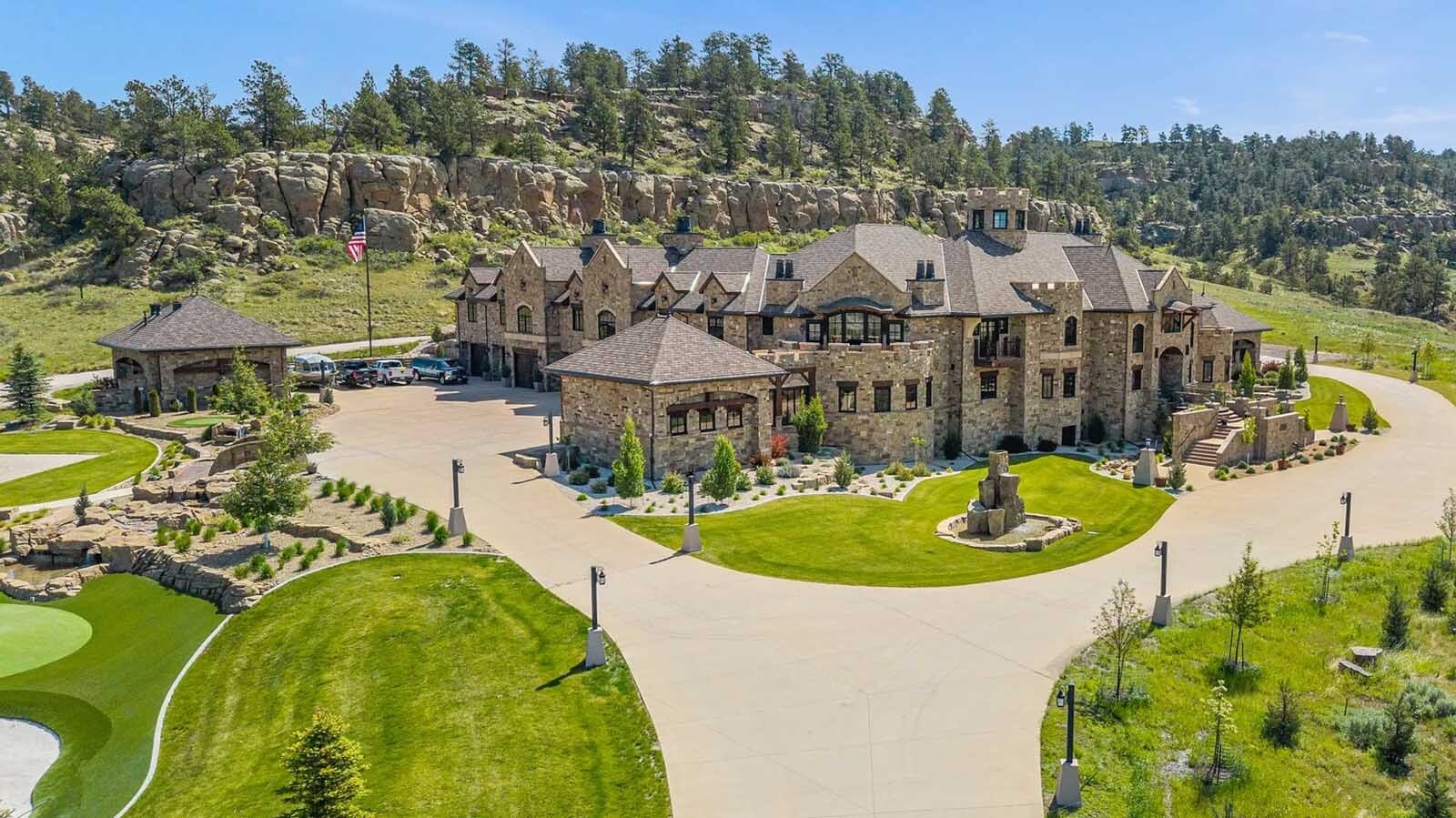 The property at 5650 Canyonwoods Drive in Billings, Montana, is described as a 30,843-square-foot stone chateau with 10 bedrooms and 19 bathrooms, situated on 98 acres. The listing mentions it's priced at $26.9 million and includes amenities like three pools, a 14-car garage, elevators, indoor shooting range, bowling alley, an outdoor 3-hole golf course and an indoor golf simulator, plus a wine cellar, workout gym and theater.
