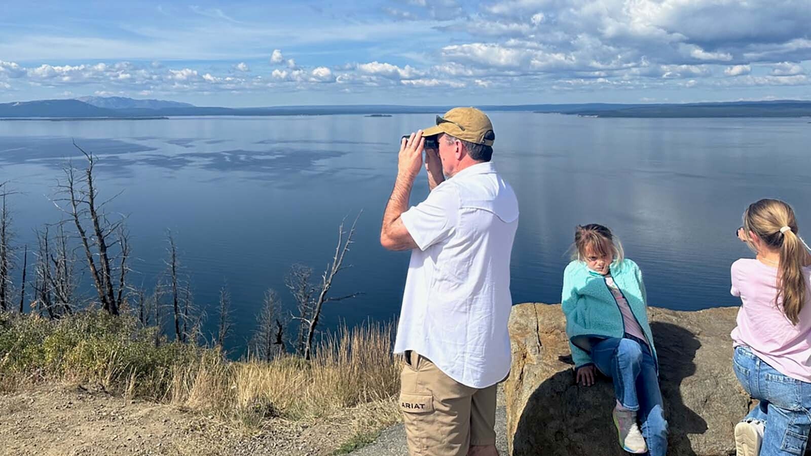 Tourists enjoy the view of the massive Yellowstone Lake, which stretches for 40 miles to the horizon. This is Lake Butte Overlook.