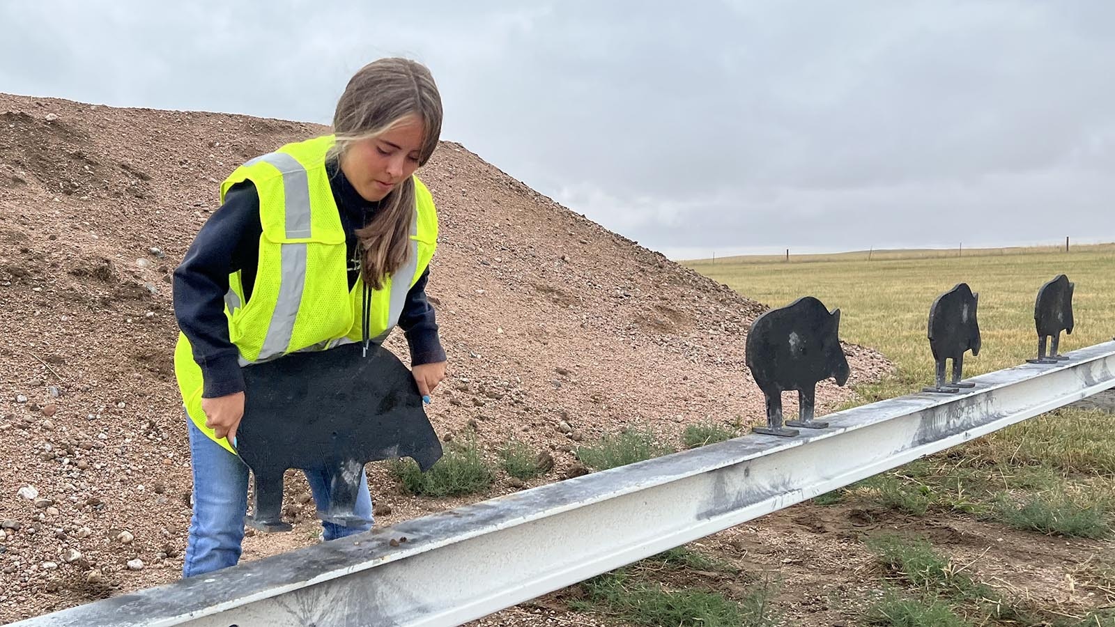 Madison Pachares re-sets an iron pig silhouette target between rounds at a black powder cartridge shooting match at the Smithmoor BPCR Range near Carpenter on Thursday.