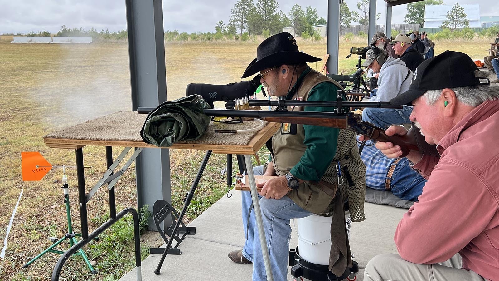 Thomas Moore of Buffalo takes aim with his rifle while Laramie County resident Scott “Griz” Stephenson prepares to spot downrange hits at the Smithmoor Cup black powder cartridge rifle match near Carpenter on Thursday.