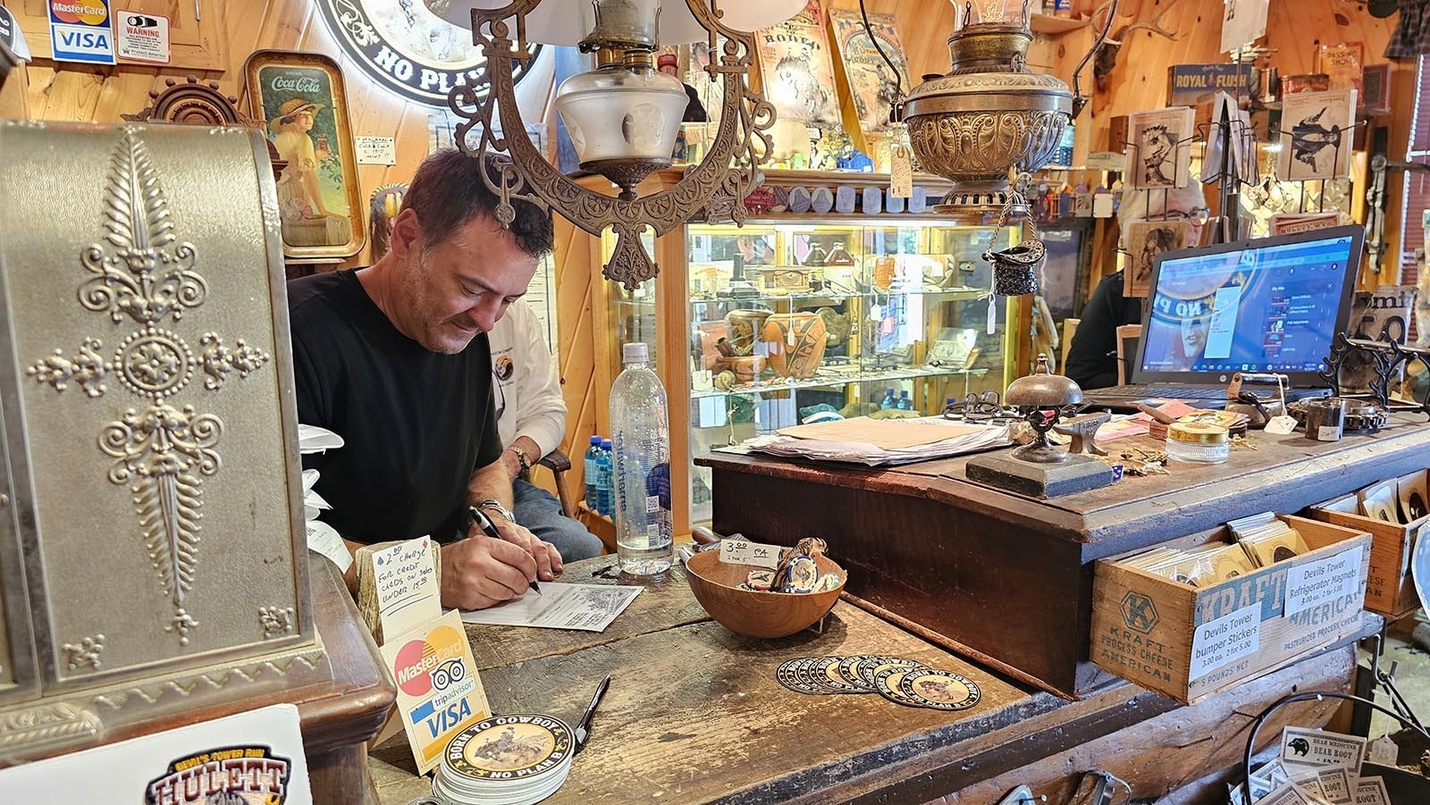 Bob Coronato fills out a sales ticket at his store, Rogue's Gallery, in Hulett.