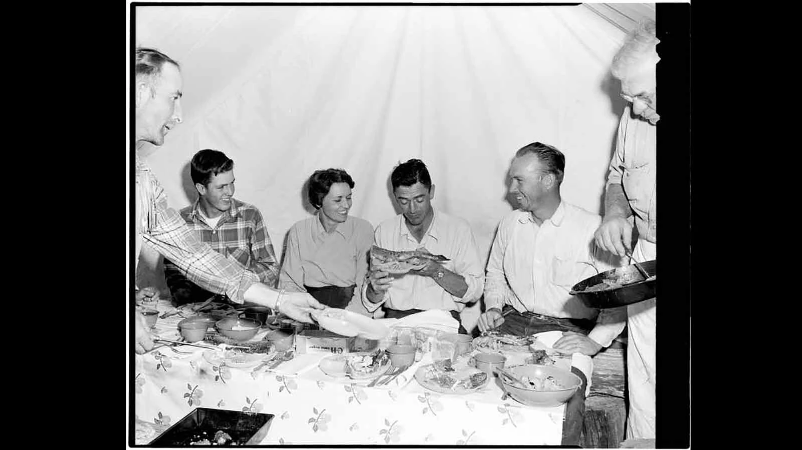 Bob Richard (second from left), friends and family chow down on some fresh trout while camping outside the Yellowstone Thororfare in 1952.