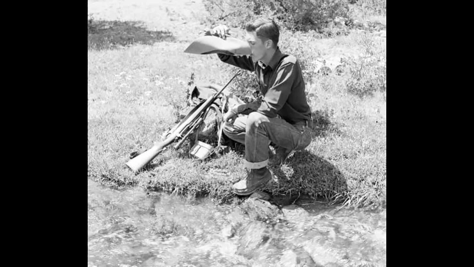 Bob Richard drinks water out Deer Creek from his cowboy hat in 1950.