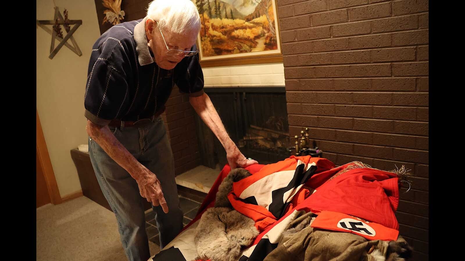  Bob Willis shows a visitor some of the souvenirs from the war that he brought back from Europe.
