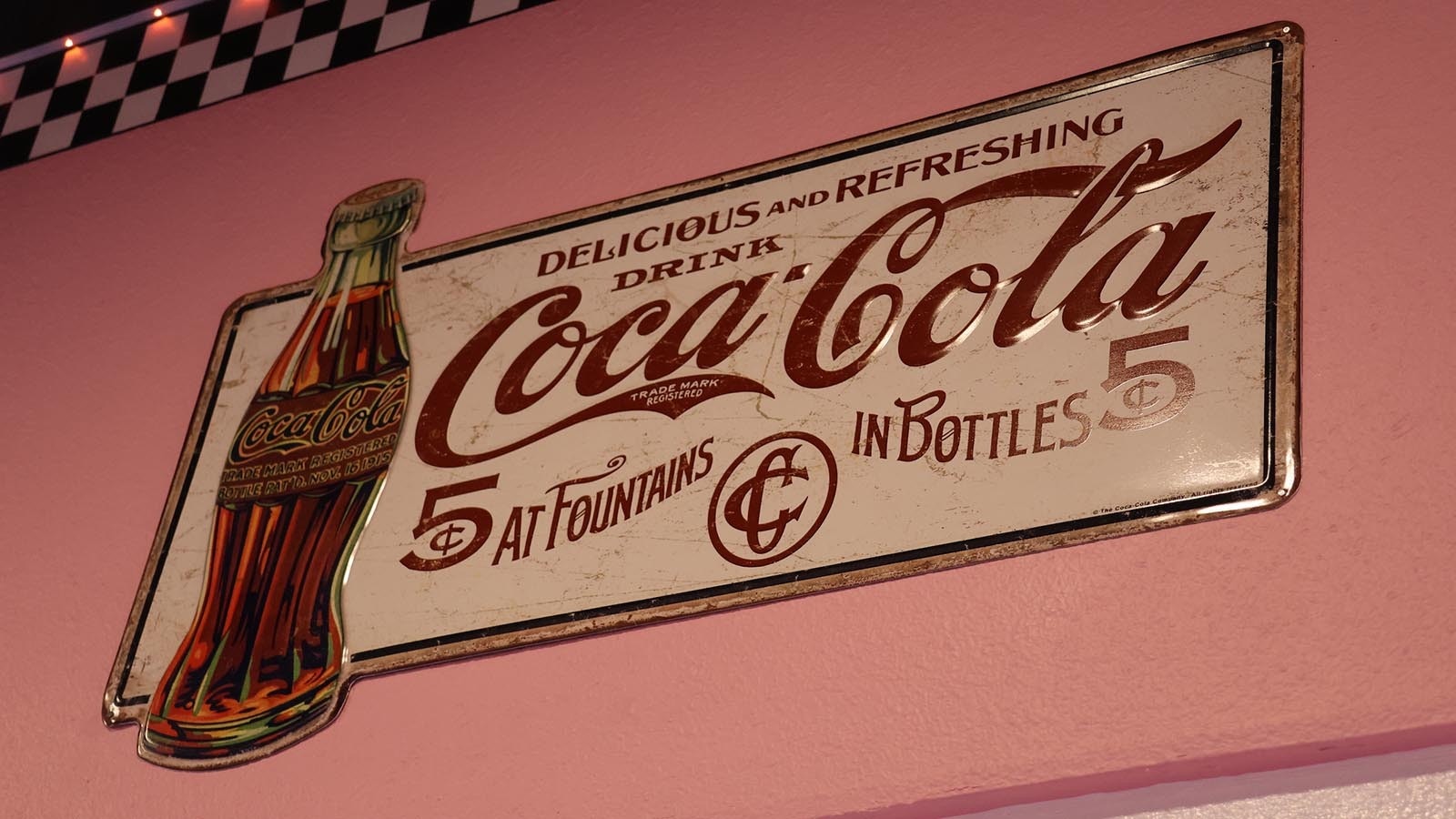 A classic Coca-Cola sign is one of many period signs and posters in the diner.