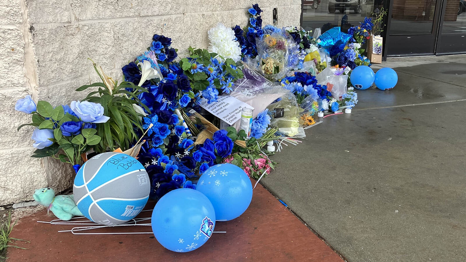 A memorial for Bobby Maher, the Casper 14-year-old who died after being stabbed outside Eastridge Mall on April 7, grows near the spot of the altercation. Maher's favorite color was blue.