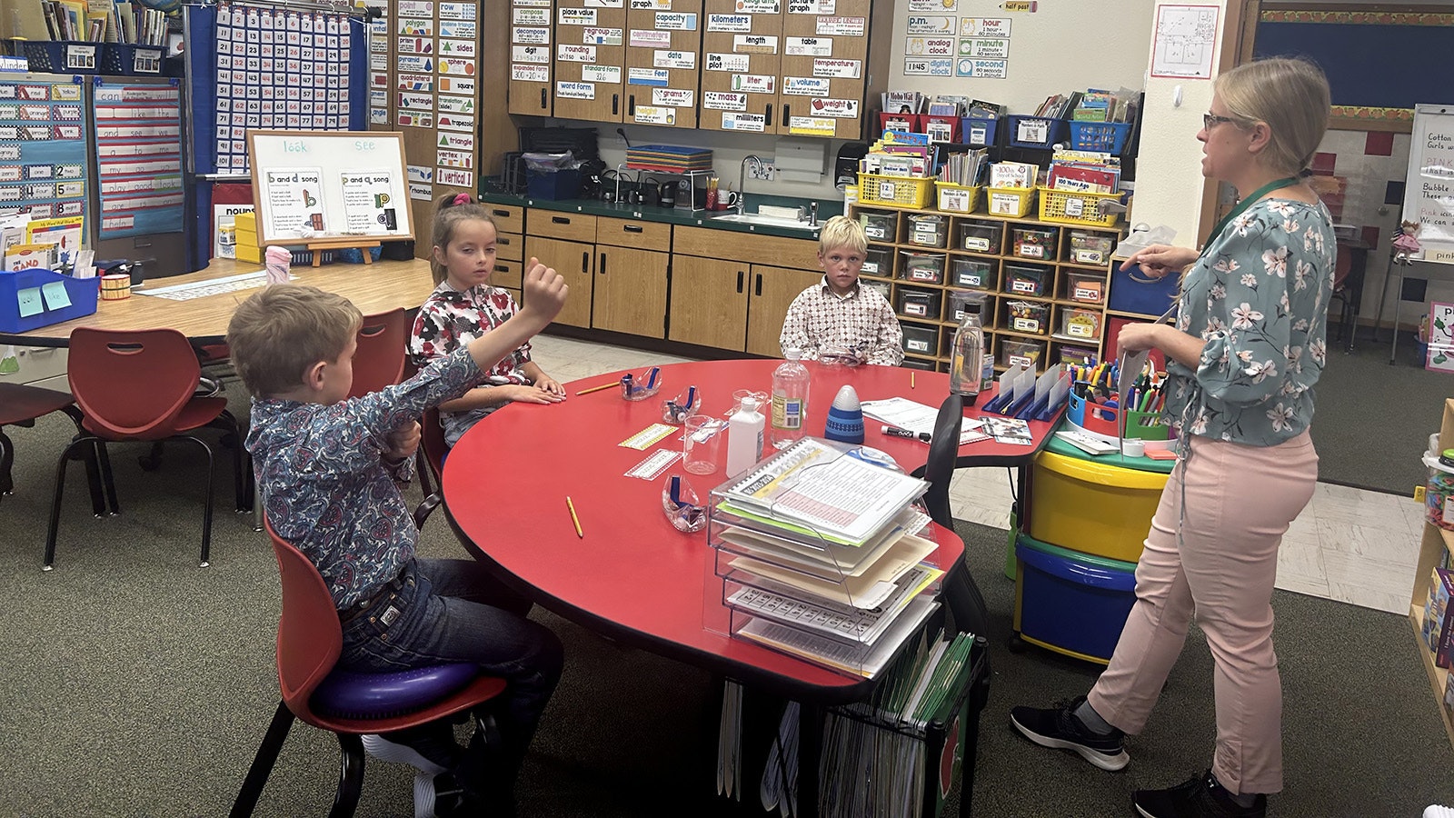 Teacher Karin Unruh gives classroom instruction at Bondurant Elementary. Pictured from left are students Brady Saunders, Tynlee Smith and Jack Tolson.