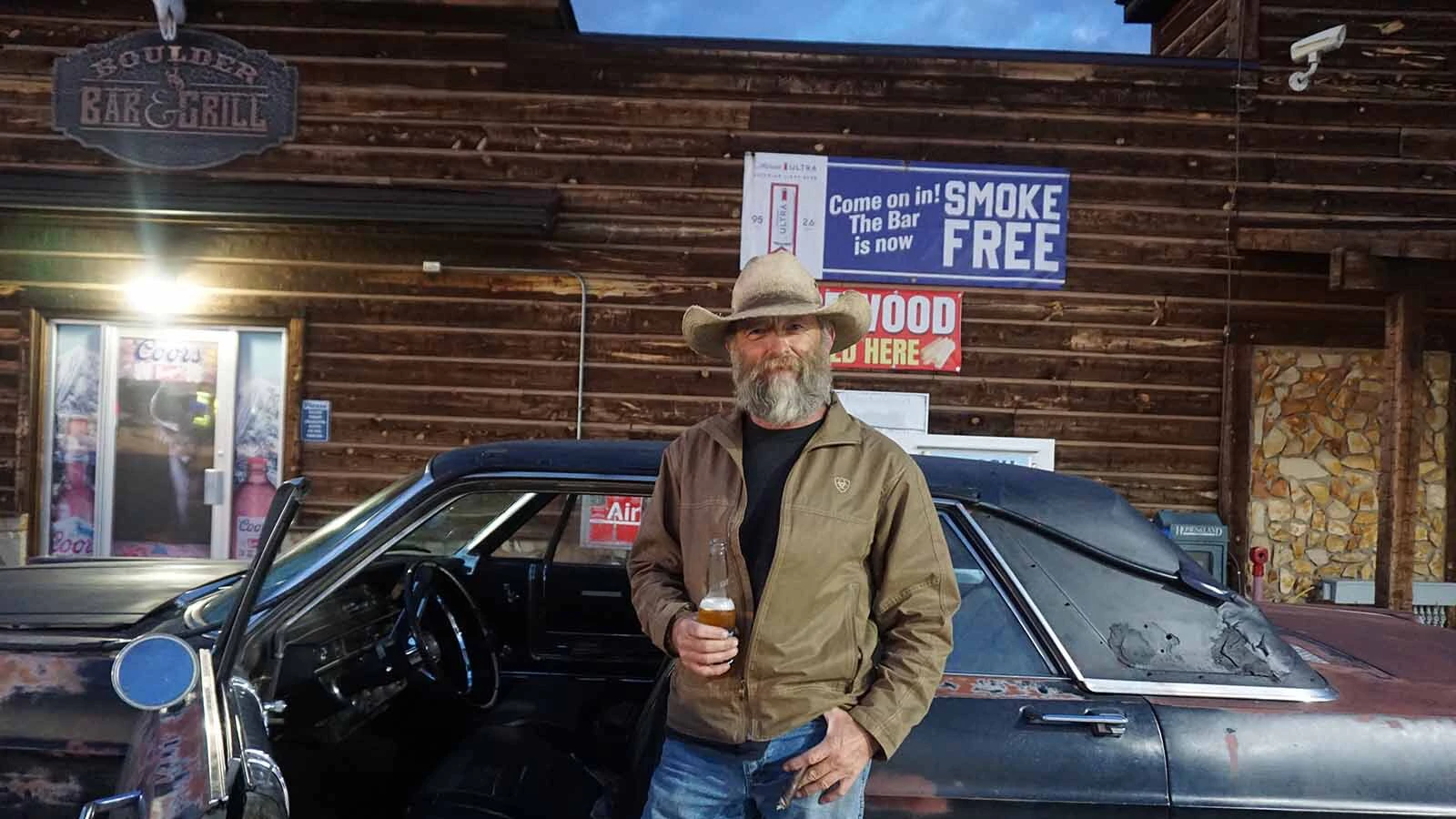 Third-generation Boulder Bar owner Burke Steele enjoys a cigar, a beer and his rusted 1965 Ford Galaxie when not running the bar.