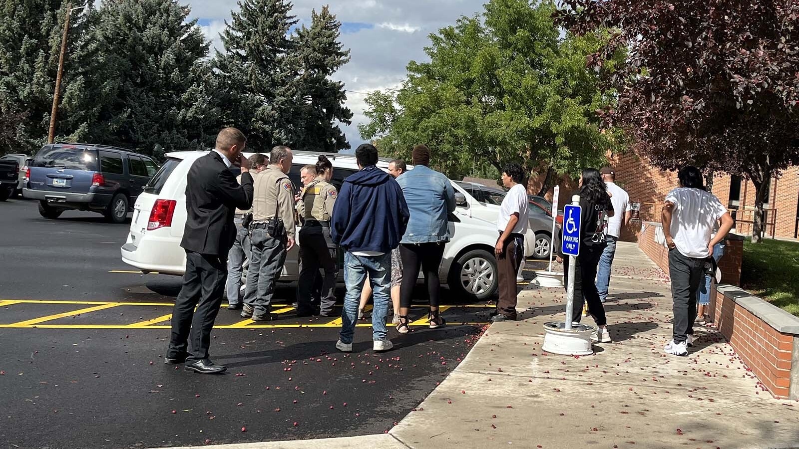 Outside the Fremont County Courthouse on Thursday after Brandon Monroe, 20, was sentenced to two life terms in prison for killing a Riverton couple in 2019. His family stands stunned around a sheriff's office transport van waiting to take him.