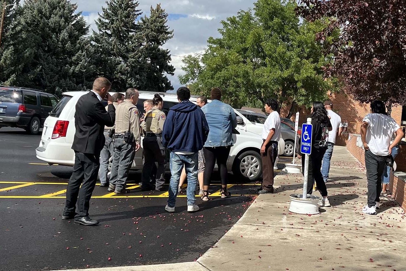Outside the Fremont County Courthouse on Thursday after Brandon Monroe, 20, was sentenced to two life terms in prison for killing a Riverton couple in 2019. His family stands stunned around a sheriff's office transport van waiting to take him.