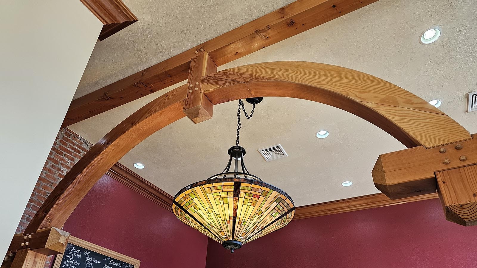 A stained glass chandelier provides soft lighting for The Bread Doctor bakery.