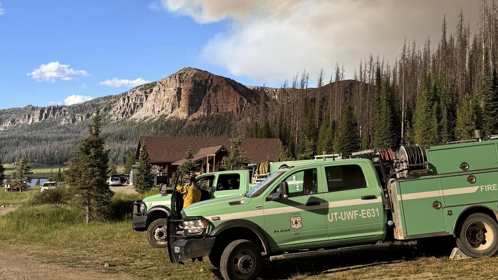 Firefighters work to protect the 102-year-old historic Brooks Lake Lodge from the Fish Creek Fire burning in northwest Wyoming.