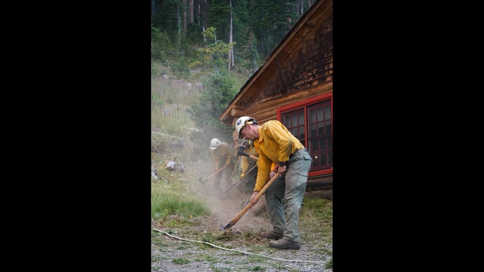 Firefighters work to protect the 102-year-old historic Brooks Lake Lodge from the Fish Creek Fire burning in northwest Wyoming.