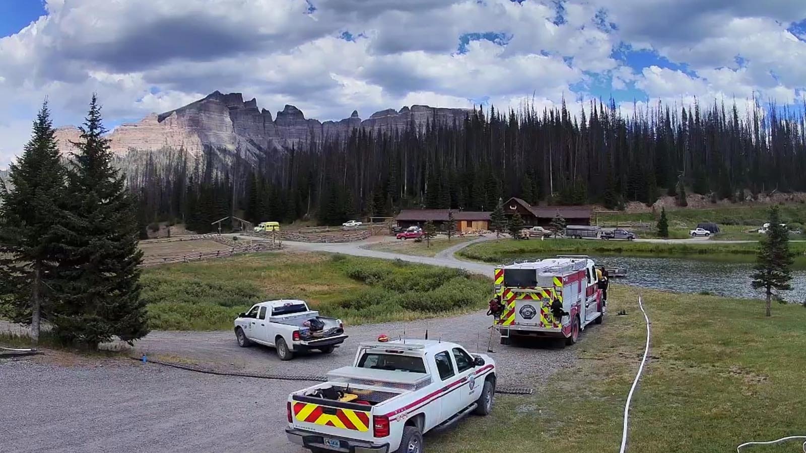 Firefighters work to protect the 102-year-old historic Brooks Lake Lodge from the Fish Creek Fire burning in northwest Wyoming.