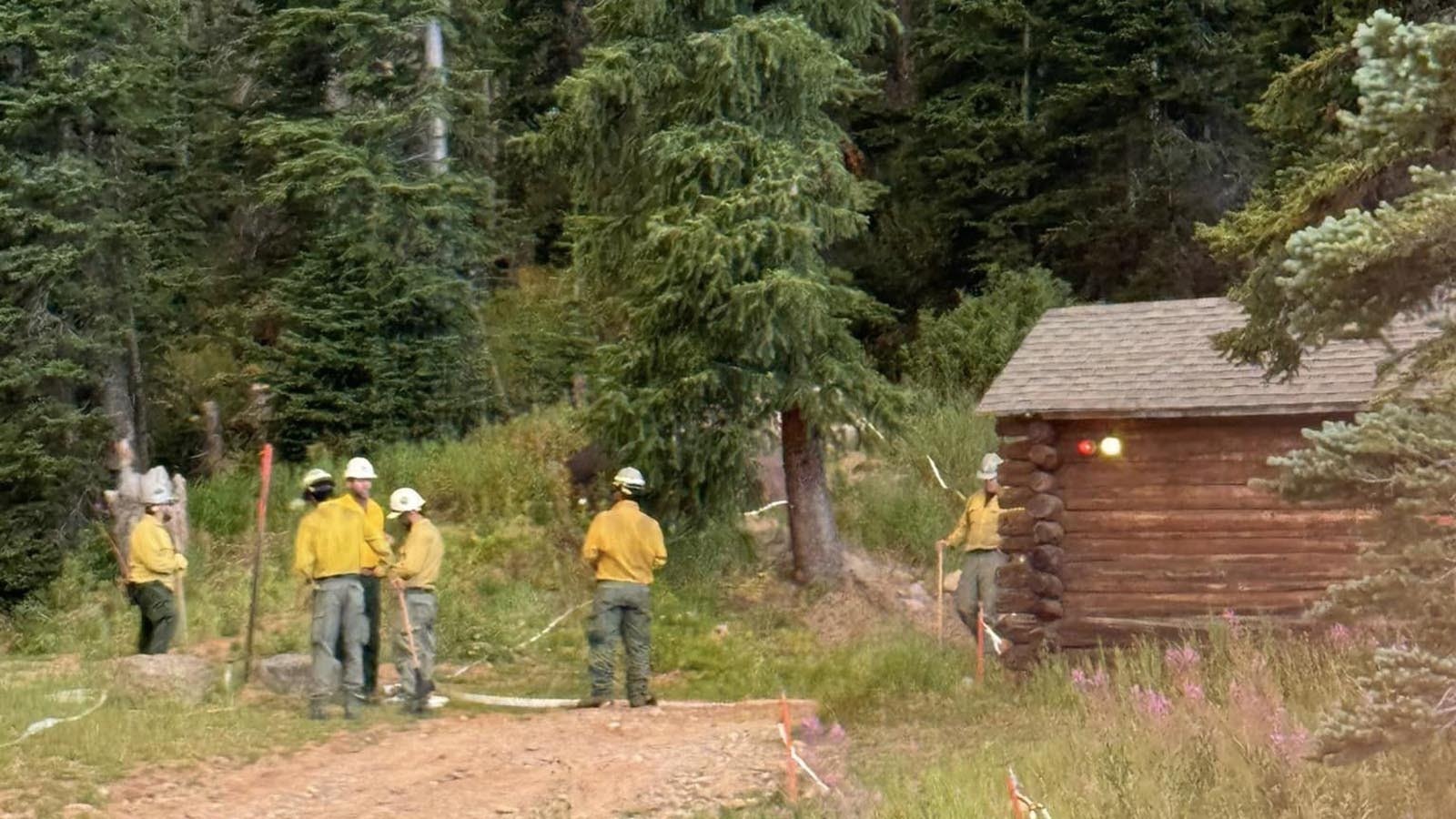 Firefighters work to protect the 102-year-old historic Brooks Lake Lodge from the Fish Creek Fire burning in northwest Wyoming.