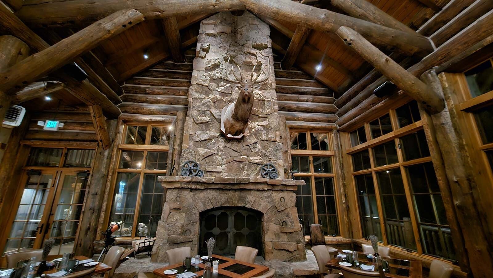 This floor to ceiling stone fireplace is a stunning backdrop at the Trailhead Lodge dining hall at Brush Creek Ranch.