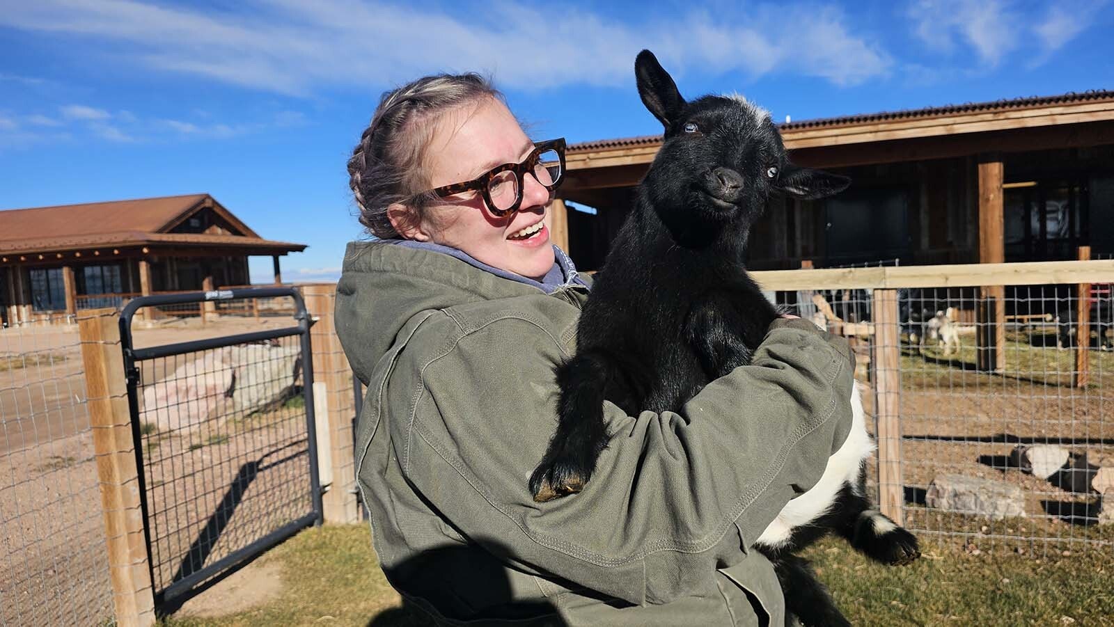 Leigh Dixon laughs as she holds one of the ornery goats that tried to steal a charging cord.
