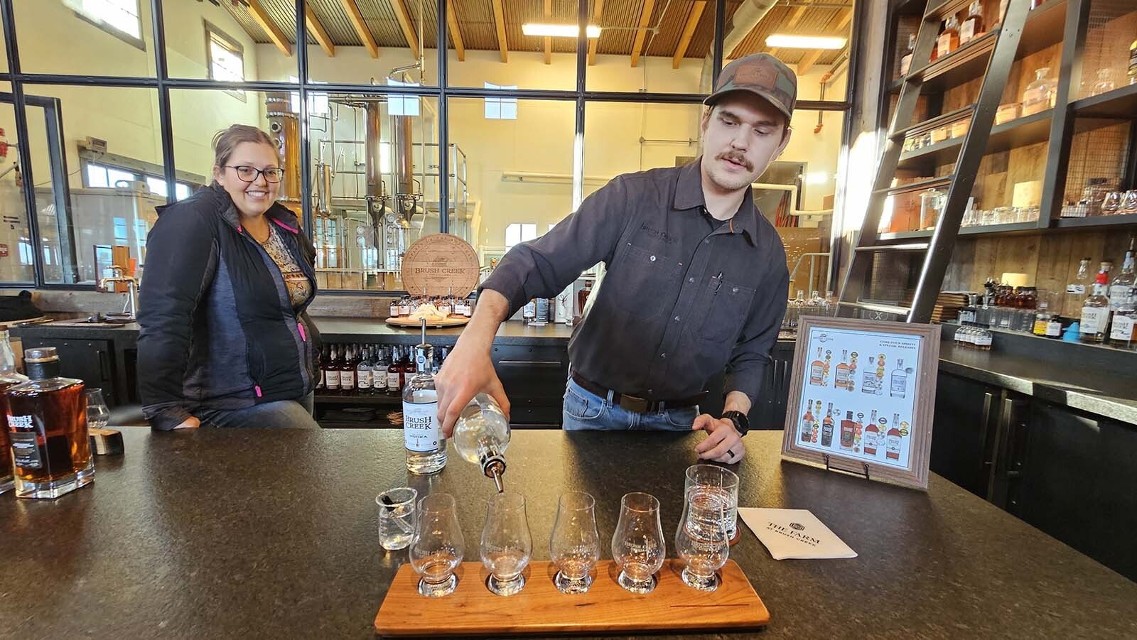 Brush Creek Ranch Lead Distiller Ethan Whitman Ethan Whitman pours out samples of distilled spirits made at Brush Creek Ranch.