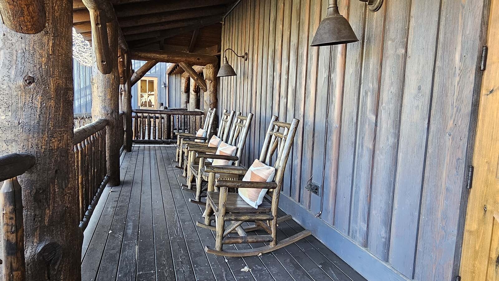 A set of rocking chairs on the front porch of the Trailhead Lodge await at Brush Creek Ranch.