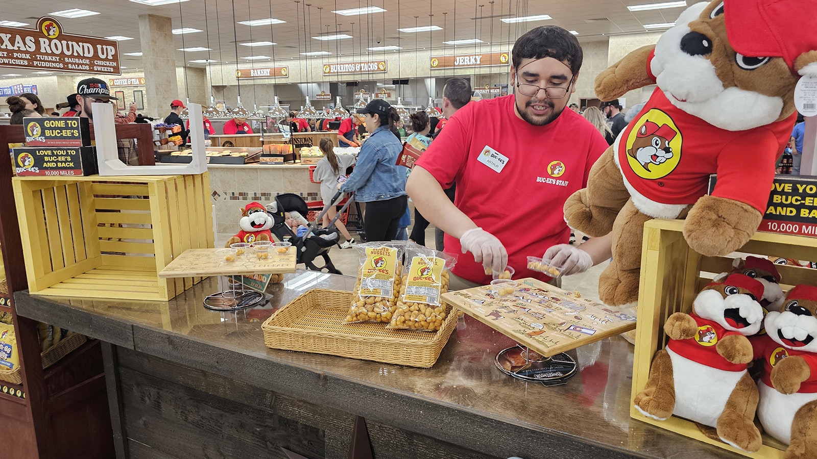 Arthur Merrival places samples of Beaver Nuggets in plastic cups for customers to try.