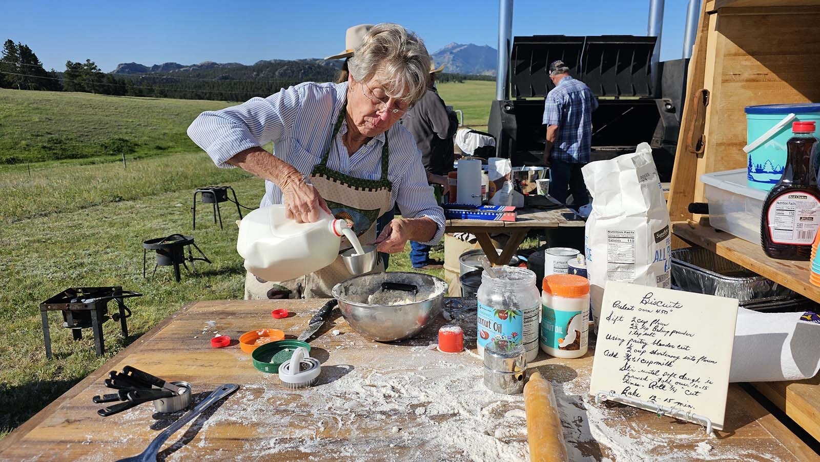 Mary Sonesen adds milk to flour cut with shortening to make biscuits for the Chuckwagon Breakfast before Buckboard Sunday at Esterbrook Church. The recipe, at right, was her mother-in-law's, Marylee Sonesen.