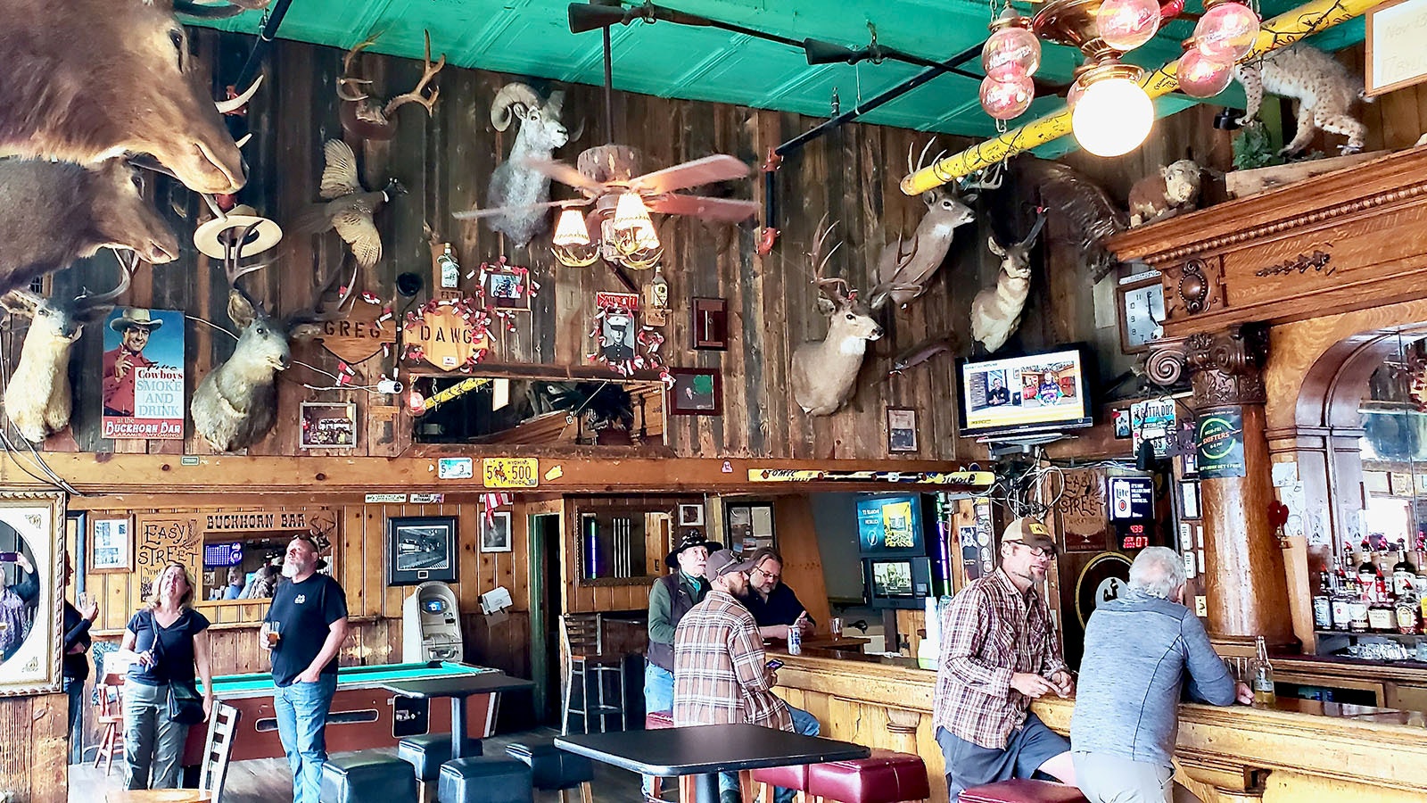 Mary Hopkins and Jerry Peterson, back left, look at murals in the Buckhorn while patrons drink at the bar.