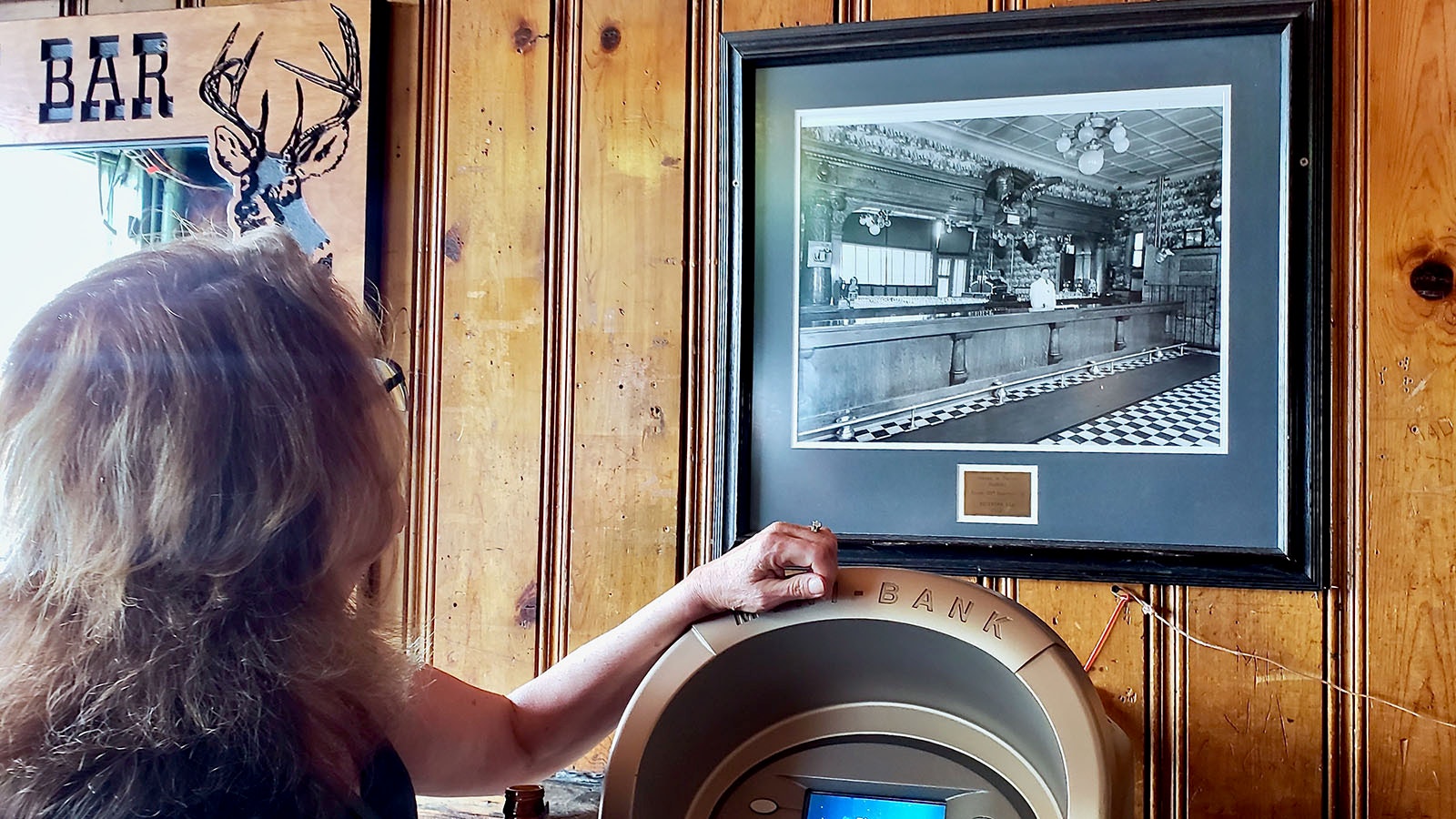 Buckhorn Bar owner Mary Hopkins looks at a photo of the Buckhorn in the 1940s.