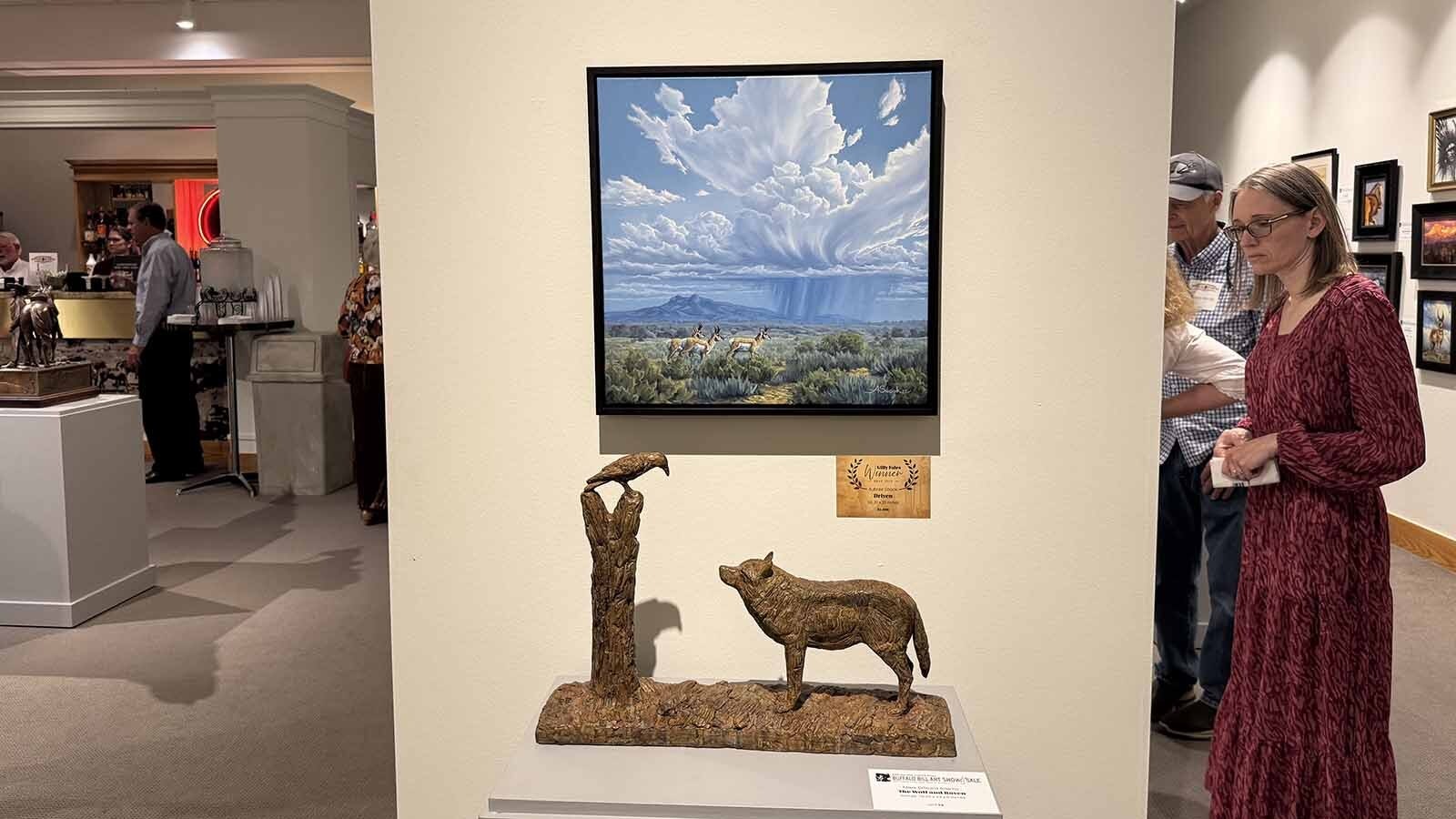 "Driven," an oil painting by Powell artist Aubree Snook, hangs above "The Wolf and the Raven," a bronze sculpture by Mark Edward Adams. Snook's painting won the Gilly Fales Fine Art Award, given to a Wyoming artist between the ages of 18 and 30.