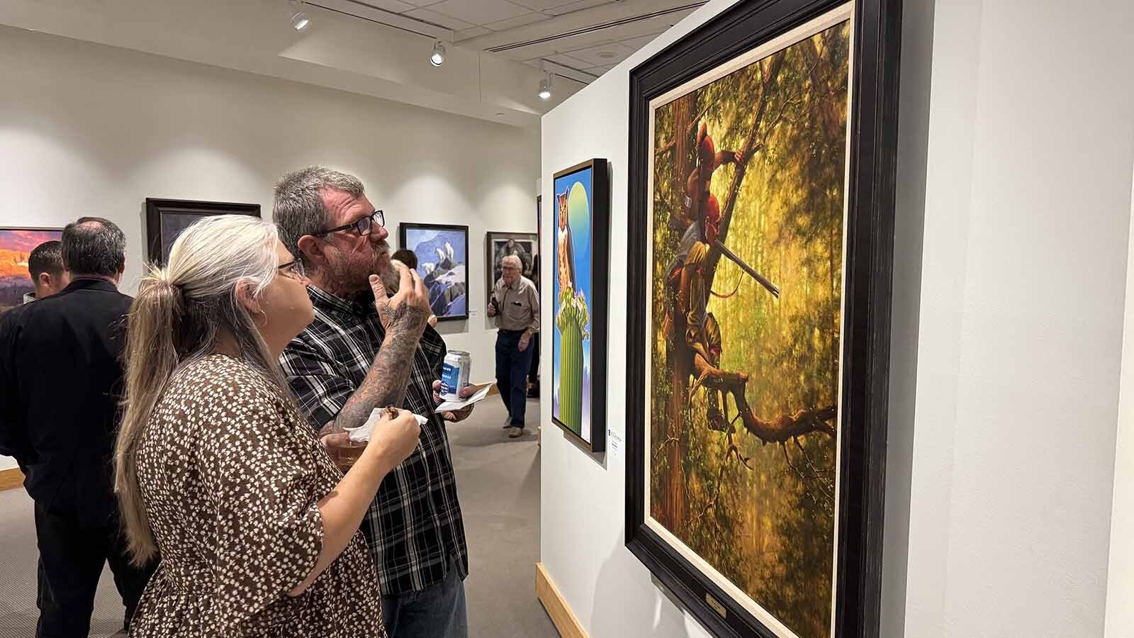 Patrons admire "Out on a Limb," an oil painting by Doug Hall, at the opening of the 44th Buffalo Bill Art Show and Sale. The gallery of 103 pieces will be open to the public, free of charge, until the live auction on Sept. 19.