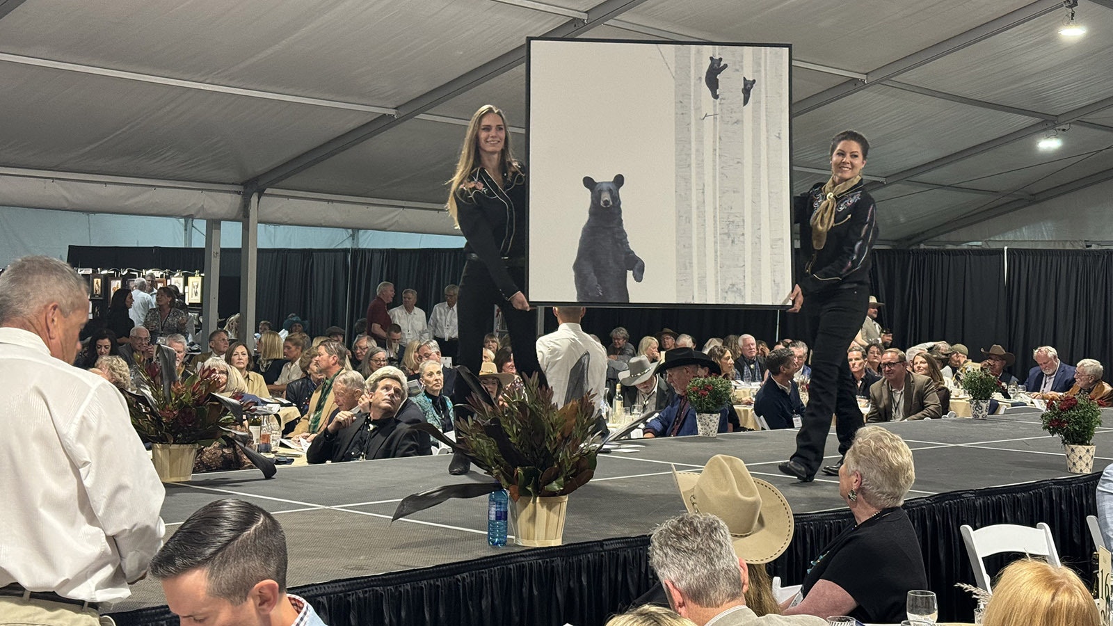 "Working Mom" by Andrew Bolam goes down the runway during the 43rd Buffalo Bill Art Show and Sale's live auction. The painting sold for $7,500.