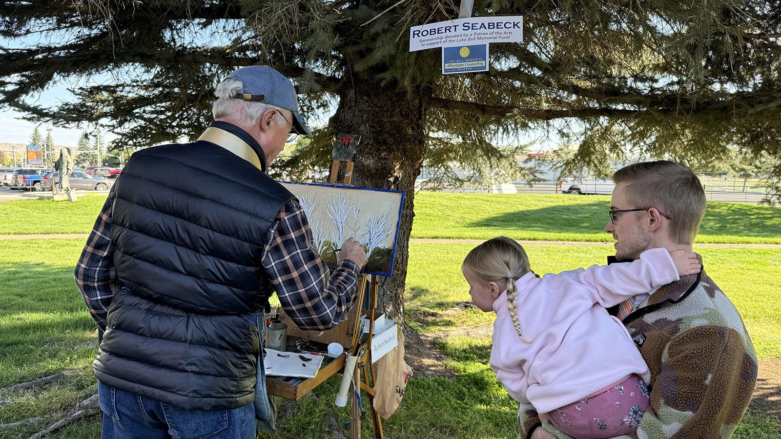 A child intently watched Robert Seabeck work on "Indian Paintbrush" during the 43rd Buffalo Bill Art Show and Sale's Quick Draw. His painting went on to sell for $2,500.