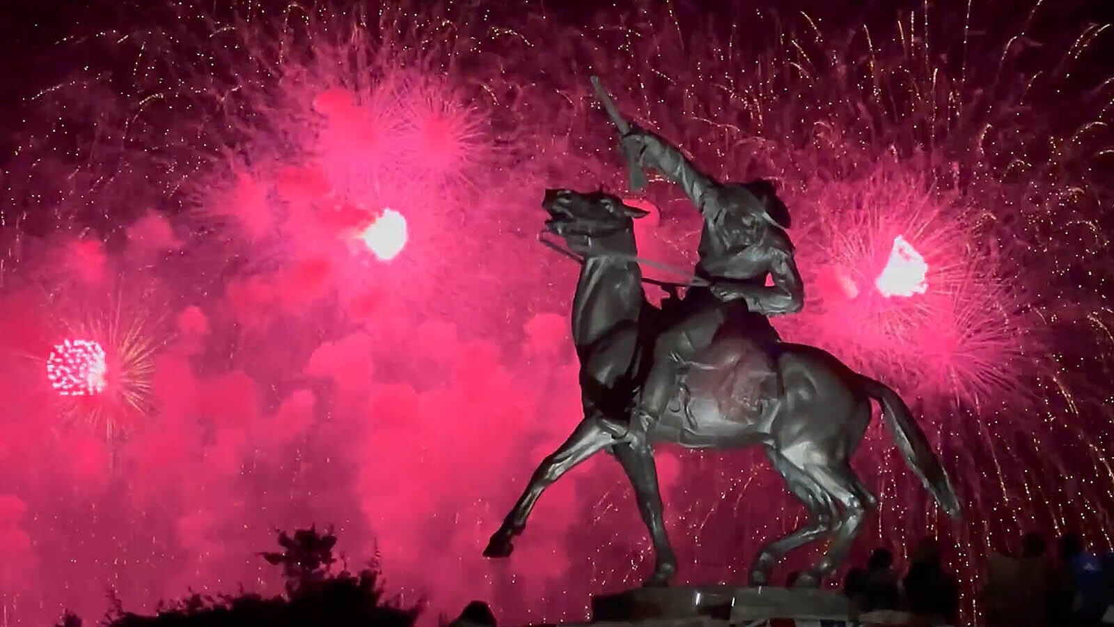 Fireworks from the Fourth of July celebration in Cody, Wyoming, on Thursday night explode behind the iconic "Buffalo Bill — The Scout" sculpture.