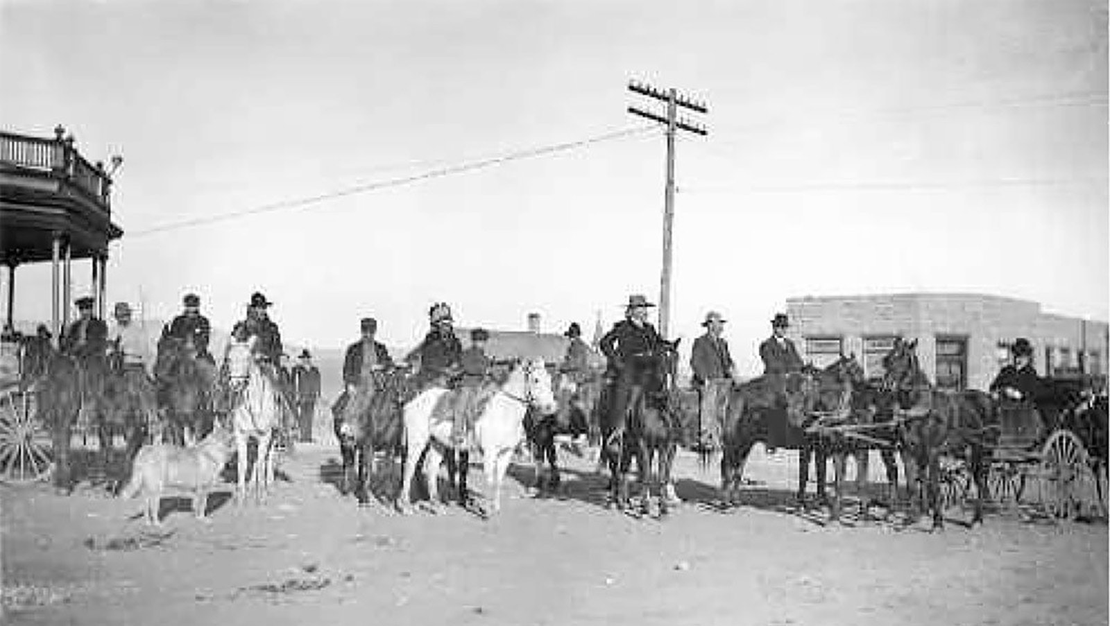 Buffalo Bill Cody with his hunting guests — what he also called his "posse" — in front of the Irma Hotel in 1904 with the First National Bank in the background.