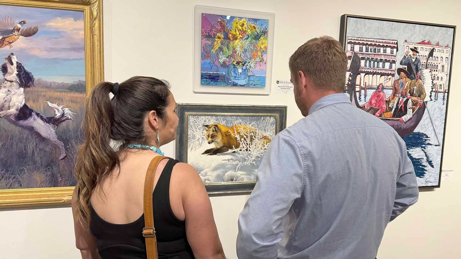 Patrons admire some of the 107 pieces of modern Western art that will be displayed and auctioned off during the opening of the 45th Buffalo Bill Art Show and Sale.