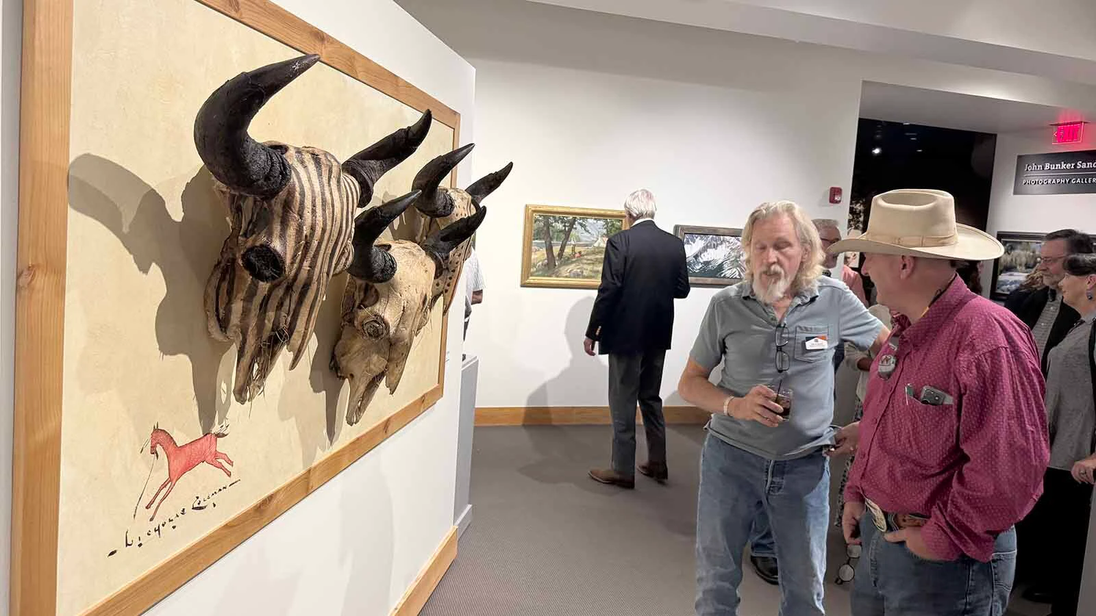 Patrons admire some of the 107 pieces of modern Western art that will be displayed and auctioned off during the opening of the 45th Buffalo Bill Art Show and Sale.