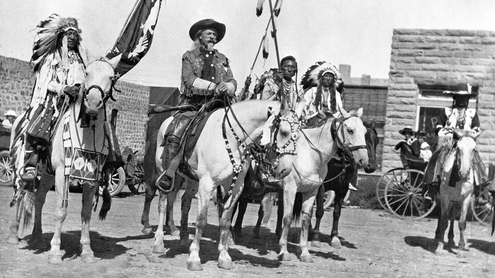 On horseback next to the First National Bank in Cody, Wyoming, in 1907 three years after a brazen bank robbery led to a shootout in the streets of Cody. Chief Iron Tail, left, was an Oglala Lakota chief who performed in Buffalo Bill Cody's Wild West Show. He's pictured here next to Cody. An unknown person is next to Buffalo Bill, and next to him is Chief Plenty Coups of the Crow Nation.