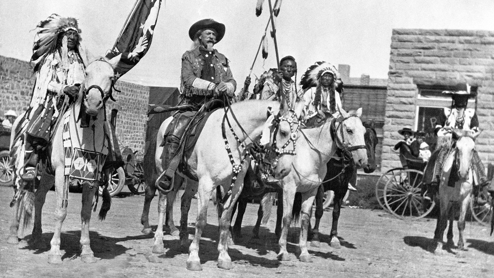 On horseback next to the First National Bank in Cody, Wyoming, in 1907 three years after a brazen bank robbery led to a shootout in the streets of Cody. Chief Iron Tail, left, was an Oglala Lakota chief who performed in Buffalo Bill Cody's Wild West Show. He's pictured here next to Cody. An unknown person is next to Buffalo Bill, and next to him is Chief Plenty Coups of the Crow Nation.