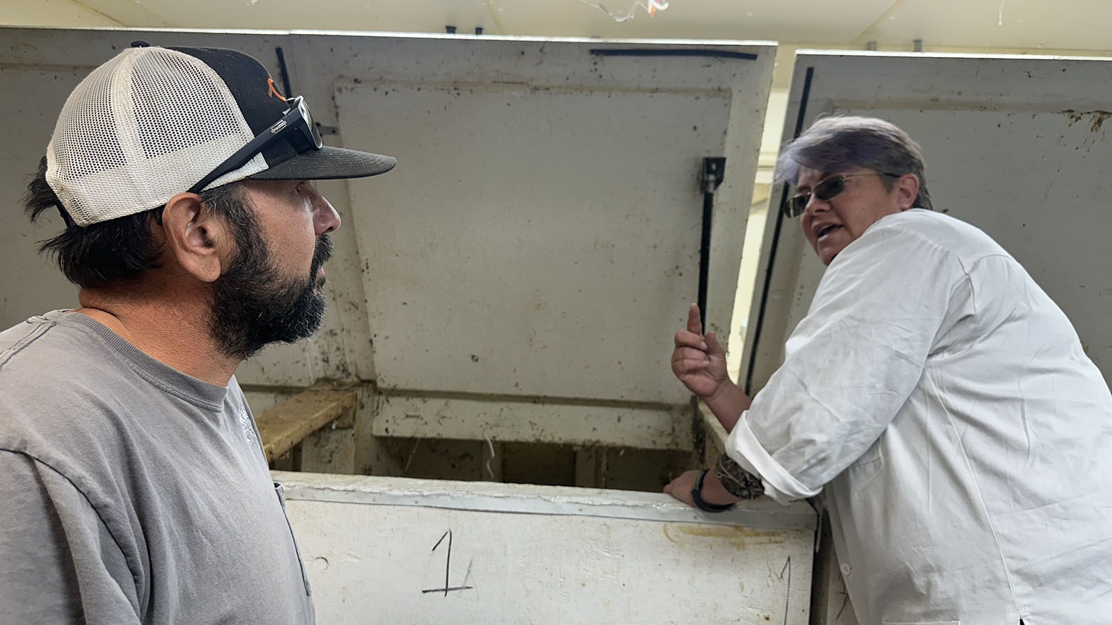 Teacher Jennifer Hammock shows a customer the bug bin. The beetles prefer the dark and warm room.