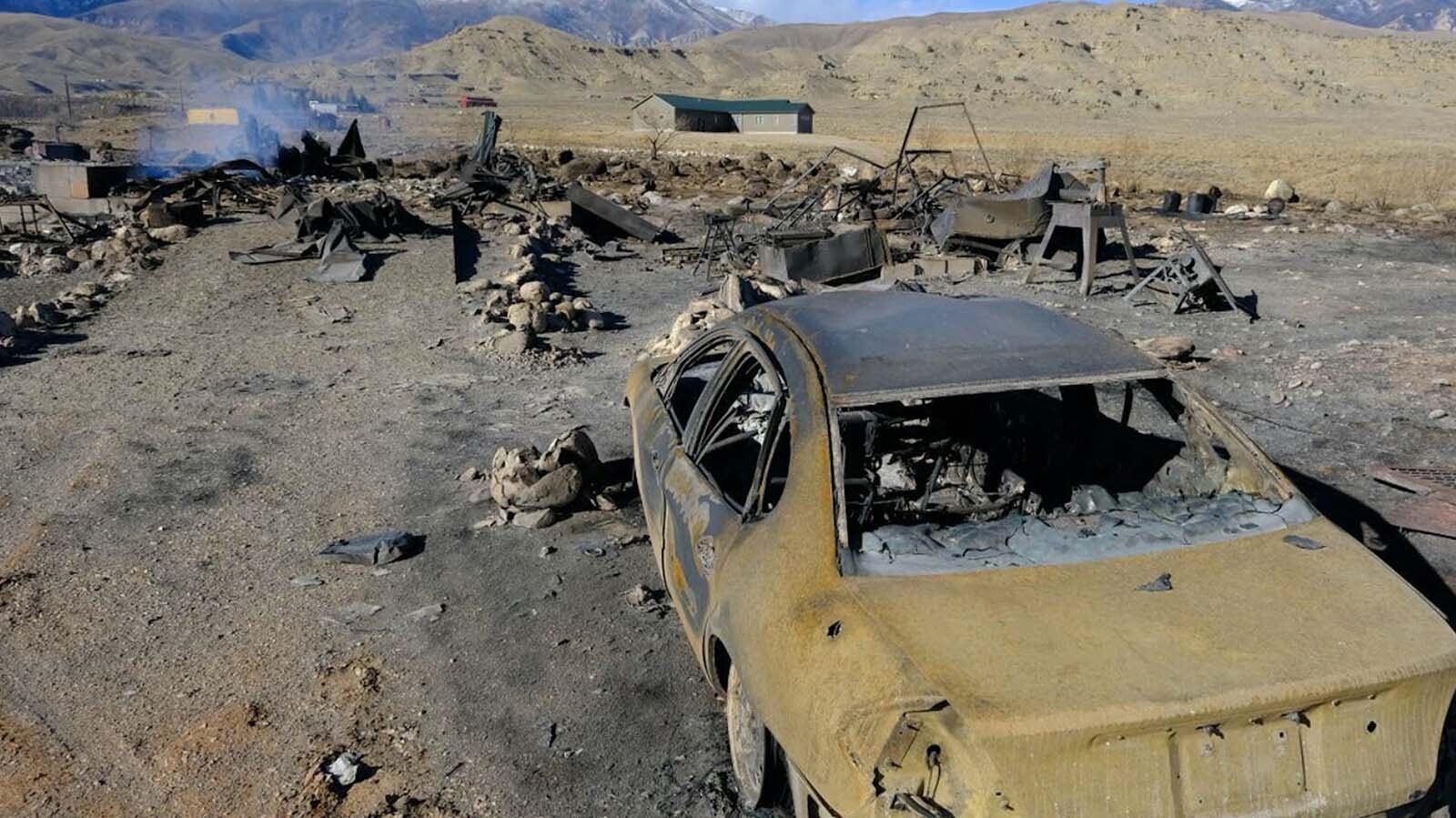 A car and burned-out remains of buildings in the aftermath of the November 2021 Clark Fire.